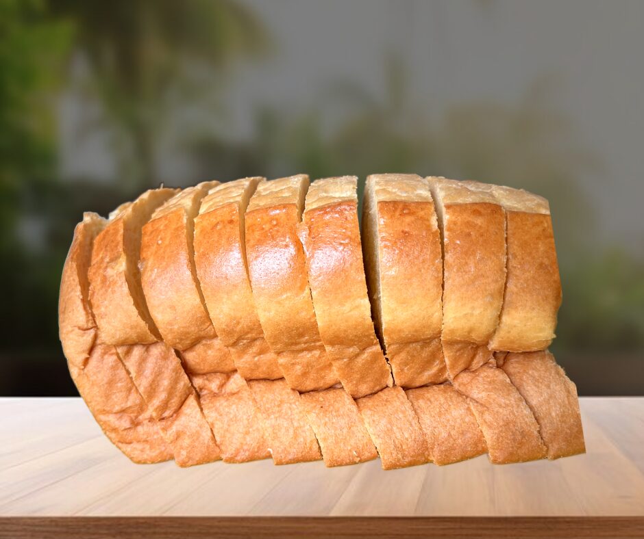 Golden sliced pullman loaf resting on dark wood serving board.